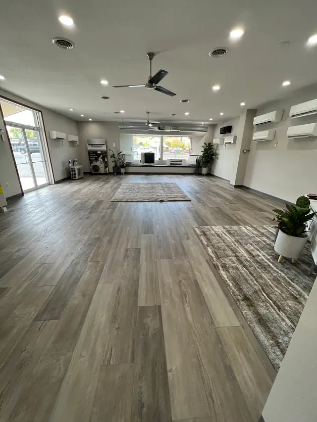 Several ductless wall units mounted high in a large open room with wood floors