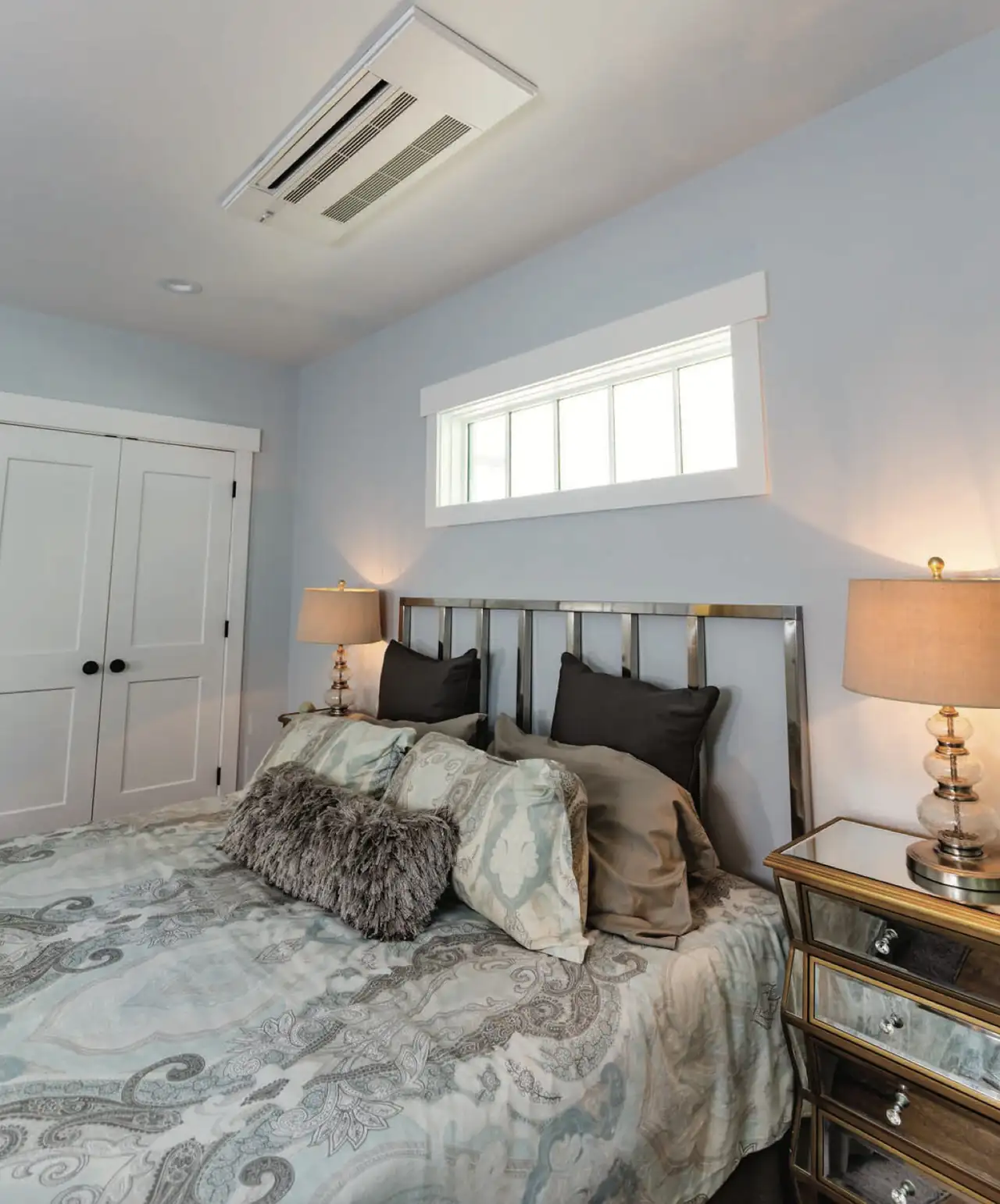 A Mitsubishi ceiling cassette installed above the bed in a finished bedroom